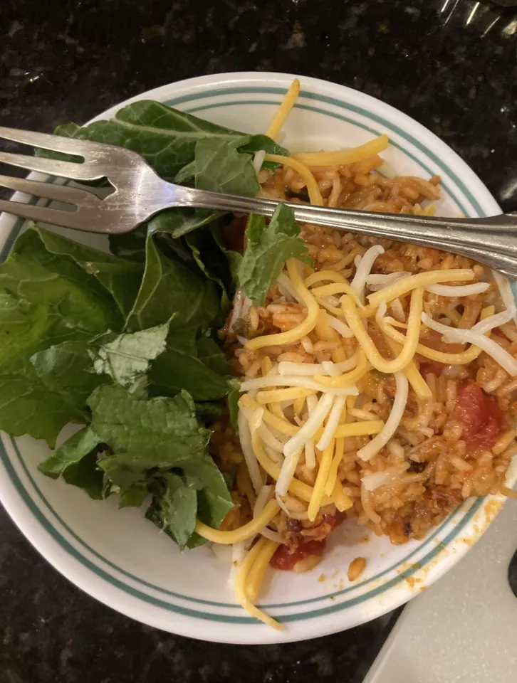 shredded cheese and a side of fresh green lettuce leaves, accompanied by a fork